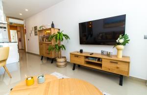 un soggiorno con una grande TV a schermo piatto a parete di By the sea, Algarve a Galé