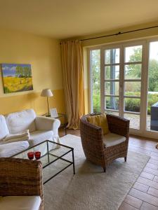 salon z kanapą, krzesłami i oknami w obiekcie Fleesensee Resort & Spa w mieście Göhren-Lebbin