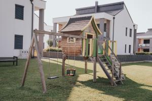 een speeltuin in een tuin met een speelplaats bij Apartments Sunrise Banovci in Banovci