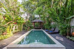 a swimming pool in a garden with a gazebo at Villa Lunacasa, Modern Comfort in Balinese Style, 500m to beach in Seminyak