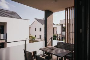 patio con mesa y sillas en el balcón en Apartments Sunrise Banovci, en Banovci
