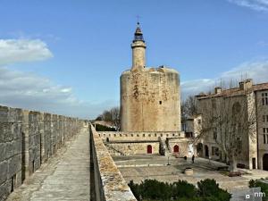 een gebouw met een toren bovenop een muur bij appartement n2 centre village, clim, parking gratuit in Aigues-Mortes