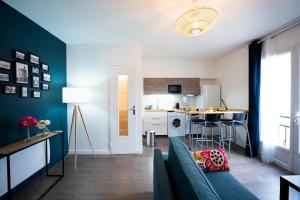 een woonkamer met een bank en een keuken bij appartement n2 centre village, clim, parking gratuit in Aigues-Mortes