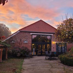 ein Backsteingebäude mit Tischen und Stühlen davor in der Unterkunft Boeren Maison in Wedde