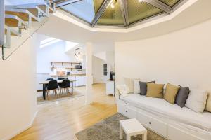 Stevan Apartment في براغ: غرفة معيشة مع أريكة بيضاء ودرج