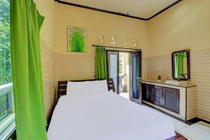 um quarto com uma cama branca e uma janela em OYO 91925 Ijo Eco Lodge Hotel em Kapal
