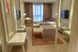 una camera d'albergo con due letti e un soggiorno di The Green Park Ankara a Ankara