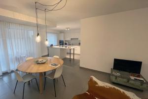 a living room with a table and chairs and a kitchen at Apartment with free covered parking - City Center in Ghent