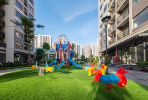 a playground with toys on the grass in a city at QMP - Vinhomes Ocean Park in Hanoi