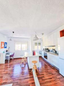 a kitchen with white cabinets and a wooden floor at Lujoso piso en Plaza de Toros in Murcia