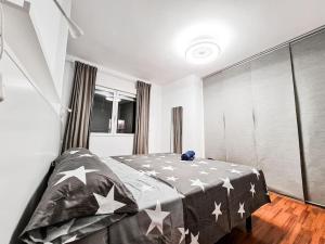 Un dormitorio con una cama con estrellas. en Lujoso piso en Plaza de Toros, en Murcia