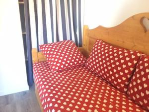 リスルにあるAppartement Risoul, 2 pièces, 6 personnes - FR-1-330-138の赤いソファ(ベッドの上に枕を用意)
