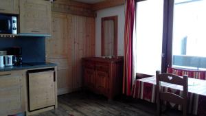a kitchen with wooden cabinets and a table and a window at Studio 20 Les Grandes Platières in Tignes