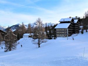 a ski lodge in the snow with people skiing at Appartement au pied des pistes avec balcon à Risoul - FR-1-330-146 in Risoul