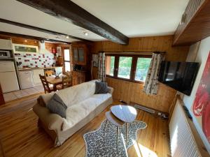 a living room with a couch and a table at LE MONTAGNARD bel appartement avec jardin dans vieille ferme de montagne rénovée in Les Orres