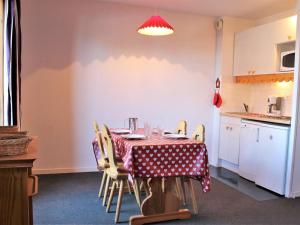 里苏尔Studio 3 couchages près des pistes, balcon, piscine, sauna, WiFi inclus, casier à ski - Risoul 1850 - FR-1-330-238的厨房里有一张桌子和几把椅子