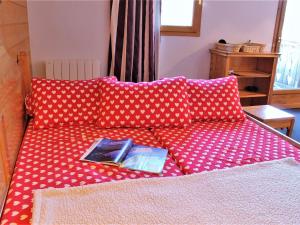 里苏尔Studio 3 couchages près des pistes, balcon, piscine, sauna, WiFi inclus, casier à ski - Risoul 1850 - FR-1-330-238的上面有一本书的红色沙发