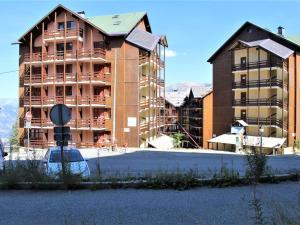 里苏尔Studio 3 couchages près des pistes, balcon, piscine, sauna, WiFi inclus, casier à ski - Risoul 1850 - FR-1-330-238的大楼前的大型公寓楼