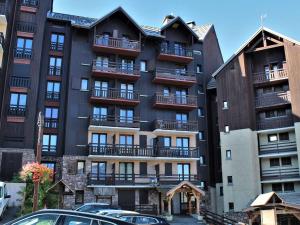 ein hohes Gebäude mit davor geparkt in der Unterkunft Appartement 3 Pièces 6 couchages avec piscine, animaux admis à Risoul 1850 - FR-1-330-209 in Risoul