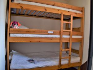 Una litera de madera con un animal de peluche en la litera inferior. en Appartement cosy à Risoul 1850 - 4 couchages, proche remontées mécaniques et commerces - FR-1-330-220, en Risoul