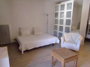 - une chambre avec un lit blanc et une chaise dans l'établissement Appartement Risoul, 1 pièce, 4 personnes - FR-1-330-237, à Risoul