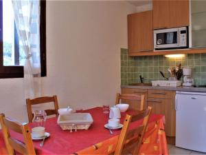 a kitchen with a table with a red table cloth at Appartement rénové 2 étoiles, pied de pistes, balcon sud, casier à ski - FR-1-330-218 in Risoul