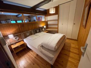 a small bedroom with a bed in a boat at LE MONTAGNARD bel appartement avec jardin dans vieille ferme de montagne rénovée in Les Orres