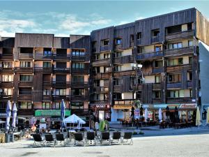 ein großes Gebäude mit Tischen und Stühlen davor in der Unterkunft Studio cabine 4 pers, pied de pistes, animaux acceptés – Risoul 1850 - FR-1-330-221 in Risoul