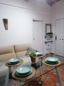 una sala de estar con 2 mesas con platos verdes. en Apartamentos miradores de granada, en Granada