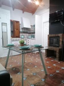 a kitchen with a glass table with plates on it at Apartamentos miradores de granada in Granada