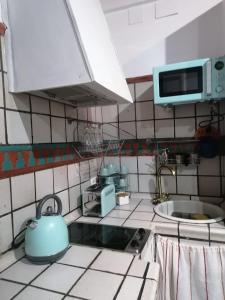 - une cuisine avec une théière bleue sur le comptoir dans l'établissement Apartamentos miradores de granada, à Grenade