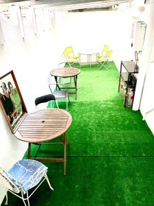 a room with green carpet and tables and chairs at Las habitaciones en Alicante in Alicante