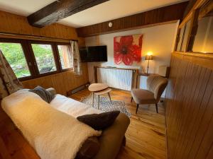 un soggiorno con divano e sedia di LE MONTAGNARD bel appartement avec jardin dans vieille ferme de montagne rénovée a Les Orres