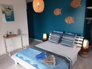 a bedroom with a large bed with blue walls at L Auberge du Pavé in Saint-Paul