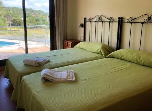 two beds in a bedroom with two towels on them at Apartamentos aDoniña Playa Major Sanxenxo in Sanxenxo