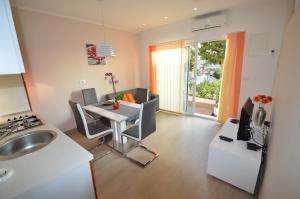 a kitchen and living room with a table and a sink at Apartments Milanović in Mali Lošinj