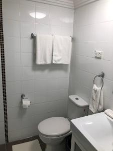 a bathroom with a toilet and a sink and towels at Sunny Rooms Mascot in Sydney