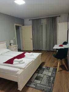 a bedroom with a large white bed and a desk at Provincial in Vişeu de Jos