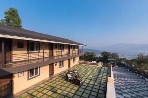 a building with a courtyard with chairs and grass at Asanjo Villa by VEO - Part of StayVista in Mulshi