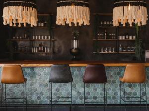 a bar with brown chairs and a counter withools at The Orpen Kruger in Welverdiend