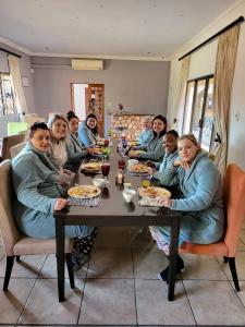 a group of people sitting at a table eating at Guesthouse Serenity in Hartbeespoort