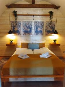 a bedroom with a large bed with two towels on it at Boti Hill Natural in Tihany