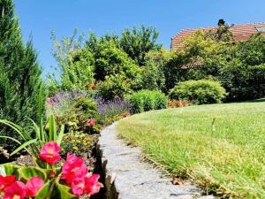 einen Garten mit rosa Blumen und einer Liegewiese in der Unterkunft Ferienwohnung Kopf in Schuttertal