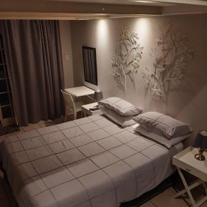 ein Schlafzimmer mit einem großen Bett mit Kissen darauf in der Unterkunft The Cradle's Rest Guest House in Krugersdorp