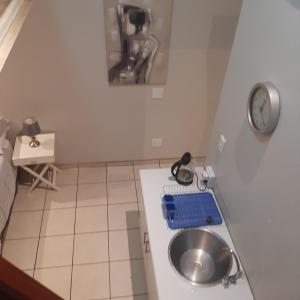 una pequeña cocina con fregadero y encimera en The Cradle's Rest Guest House en Krugersdorp