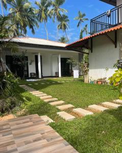 a garden with stepping stones in front of a house at River Breeze Villa Bentota in Bentota