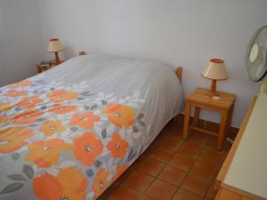 a bedroom with a bed with orange flowers on it at Appartement Cerbère, 3 pièces, 6 personnes - FR-1-225C-430 in Cerbère