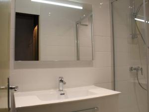 a white bathroom with a sink and a mirror at Appartement Vars, 1 pièce, 6 personnes - FR-1-330B-29 in Vars