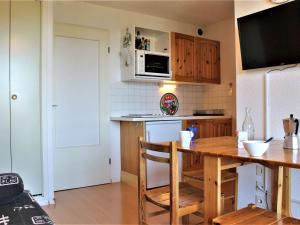 a kitchen with a wooden table and a refrigerator at Studio coin montagne 4 pers, pied de pistes à Risoul - FR-1-330-112 in Risoul