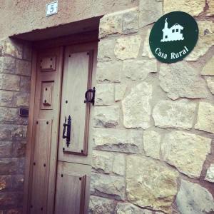 a stone building with a door and a sign on it at Casa rural hormilla in Hormilla